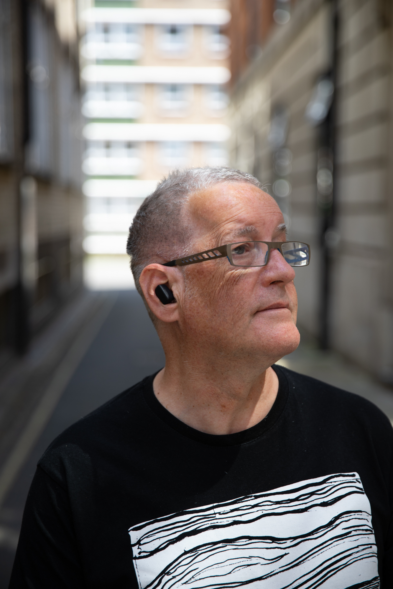 A stroke survivor wearing the June earphone stimulator during a treatment session.